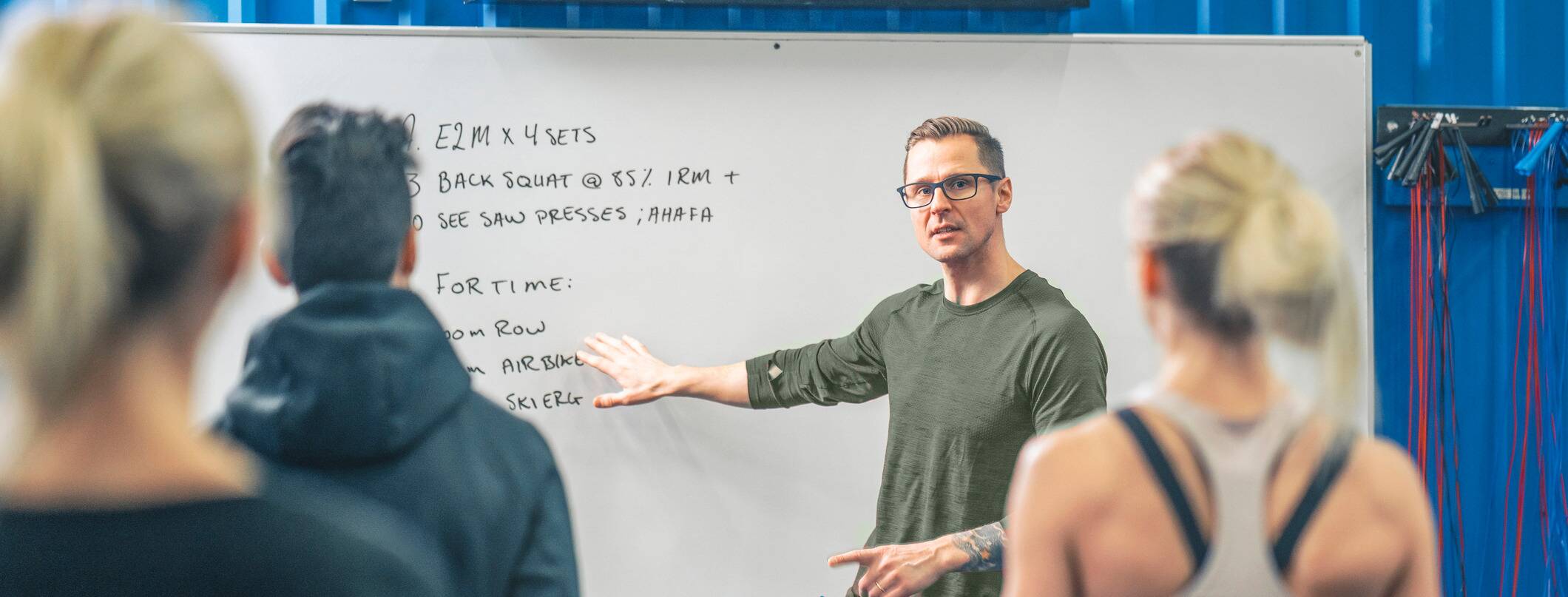 Professor explaining exercise science concepts to students in a classroom setting.