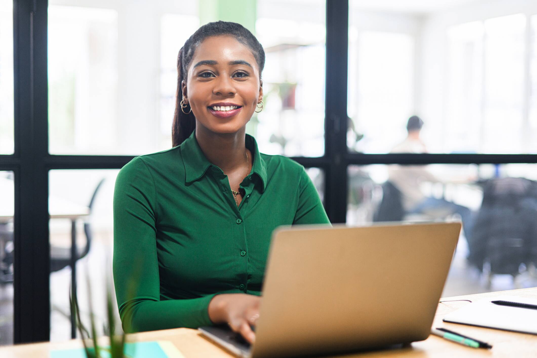 Smiling graduate working on a laptop, representing career opportunities after a master’s in exercise physiology.