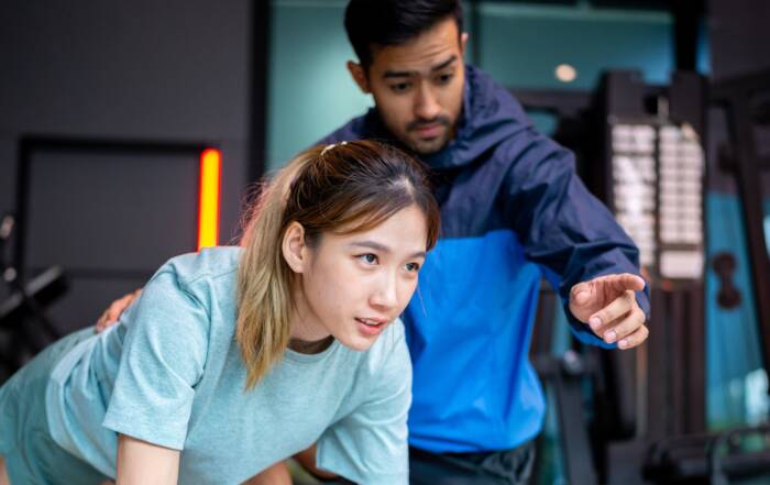 Kinesiology professional coaching a client during workout session in a modern wellness facility