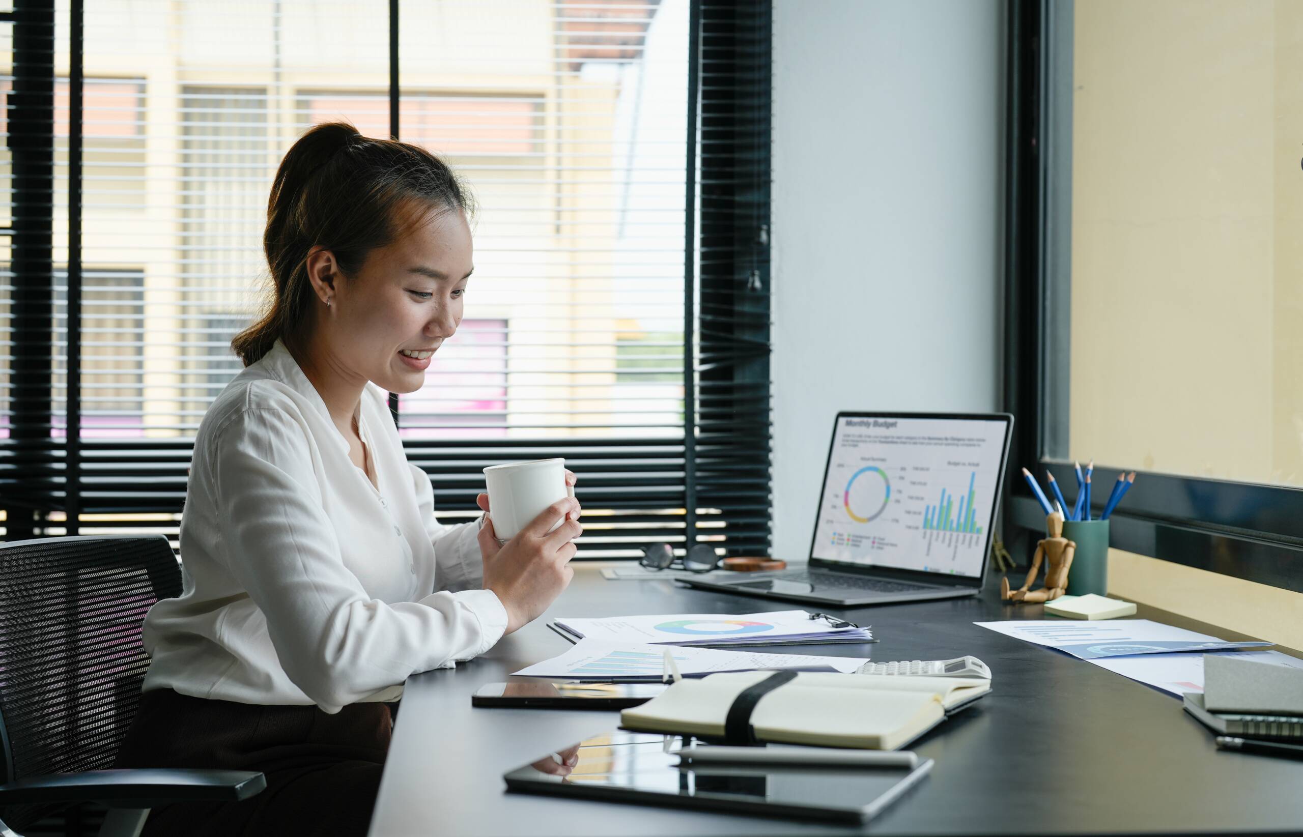 Business accountant asian woman analysis financial report at her office Professional reviewing salary trends and career data on a laptop.
