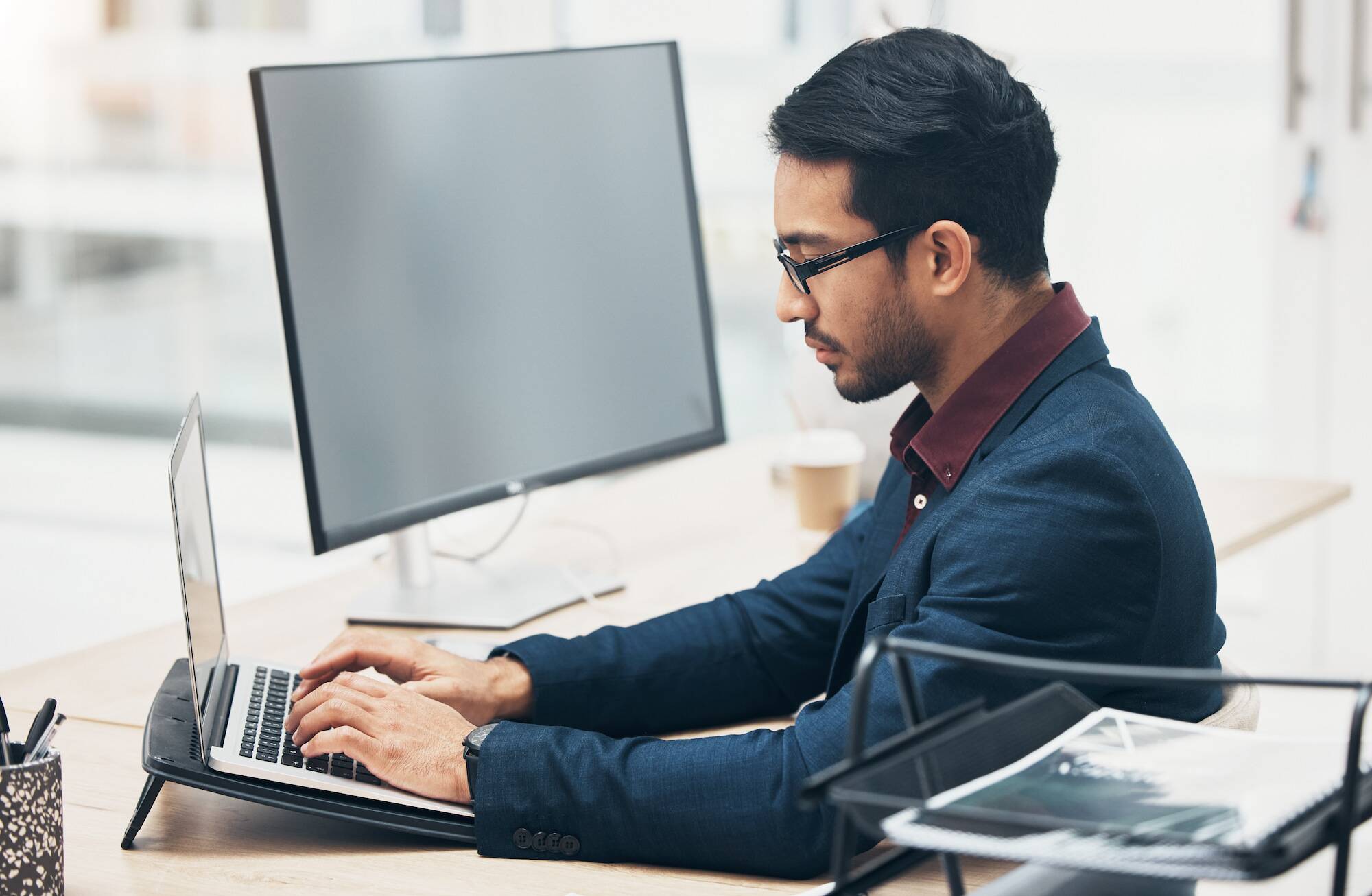 Adult student researching online college options on a computer in a modern workspace
