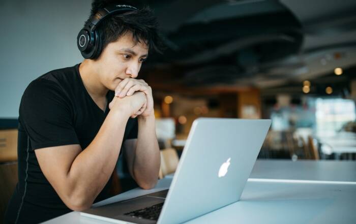 Student comparing online college programs while researching on a laptop at home