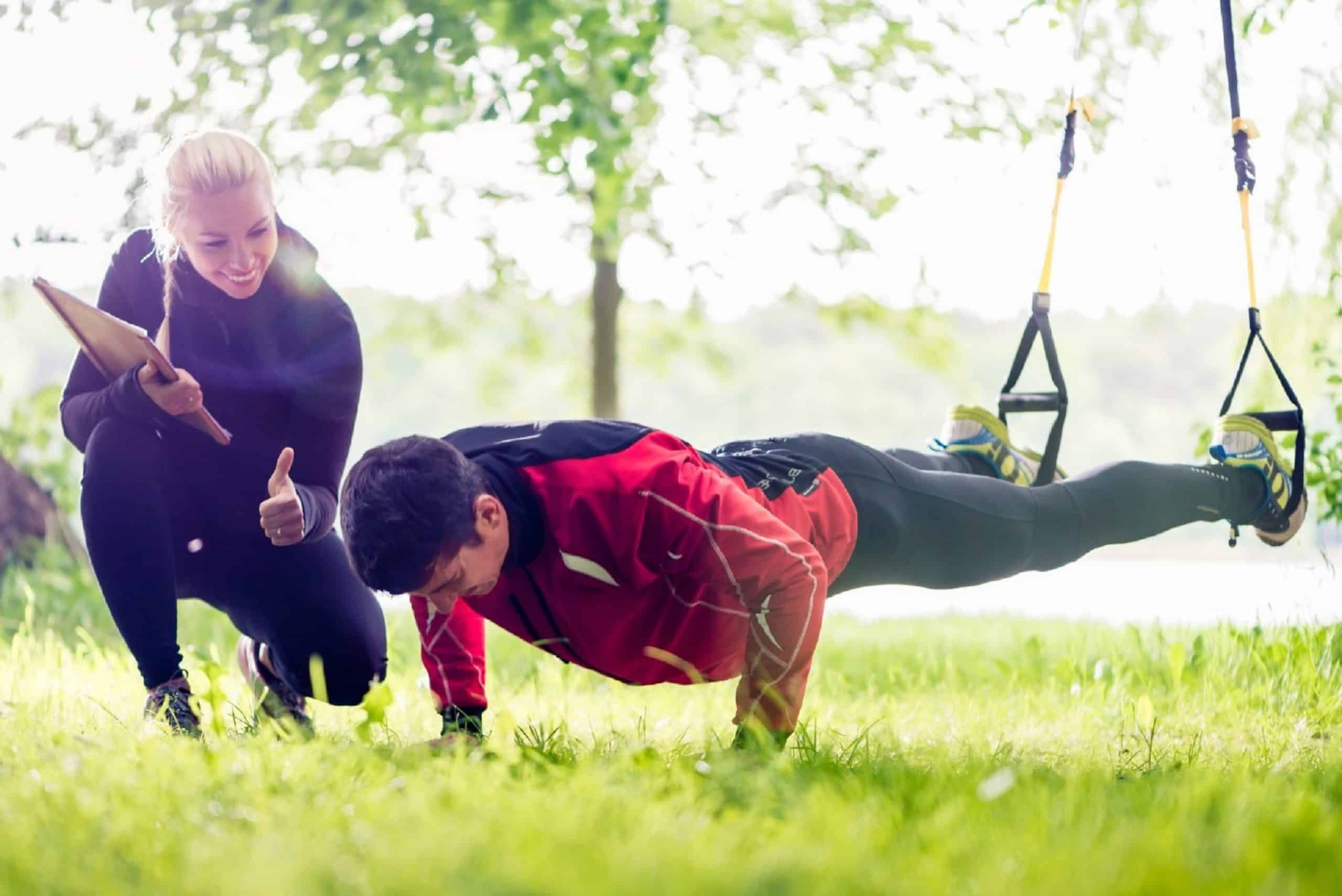 Personal trainer working with a client on TRX bands